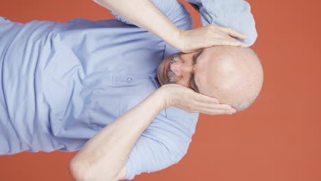 Vertical-video-of-Old-man-with-migraine-is-experiencing-pain.